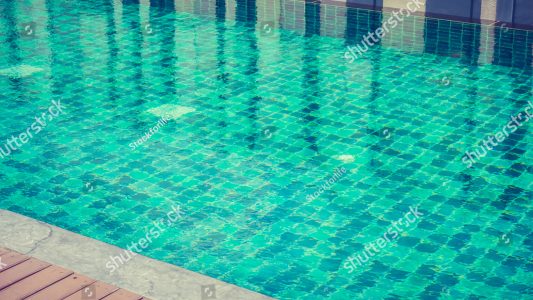 stock-photo-beautiful-outdoor-swimming-pool-in-hotel-resort-filter-effect-470240051