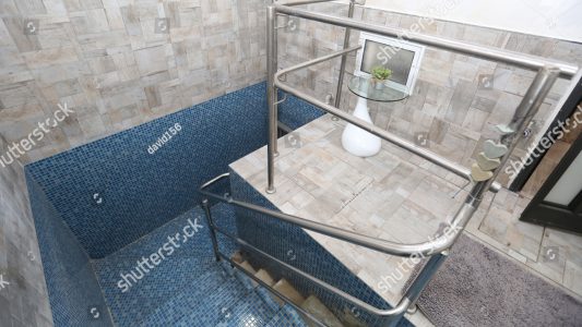 stock-photo-blue-tiled-mikveh-or-ritual-bath-with-railing-and-steps-is-used-by-jews-for-purification-1011258034